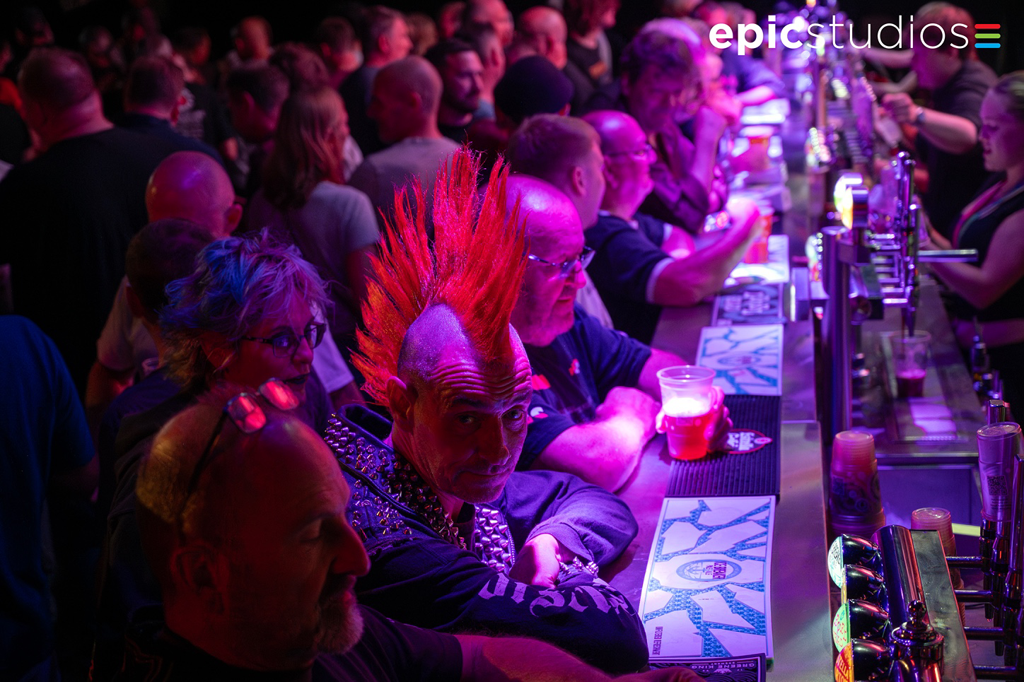 a group of people sitting at a table with purple lights
