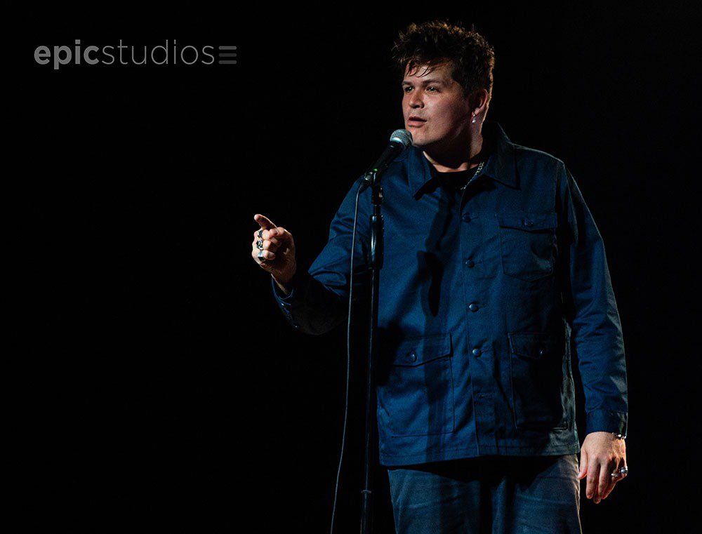 a man standing at a microphone