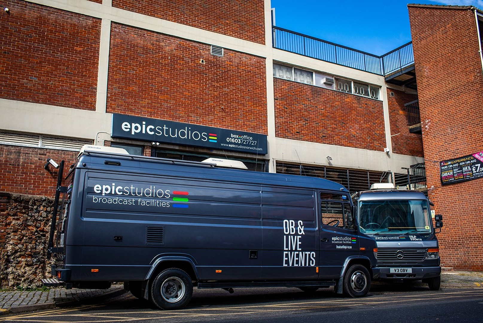 a blue truck parked in front of a brick building