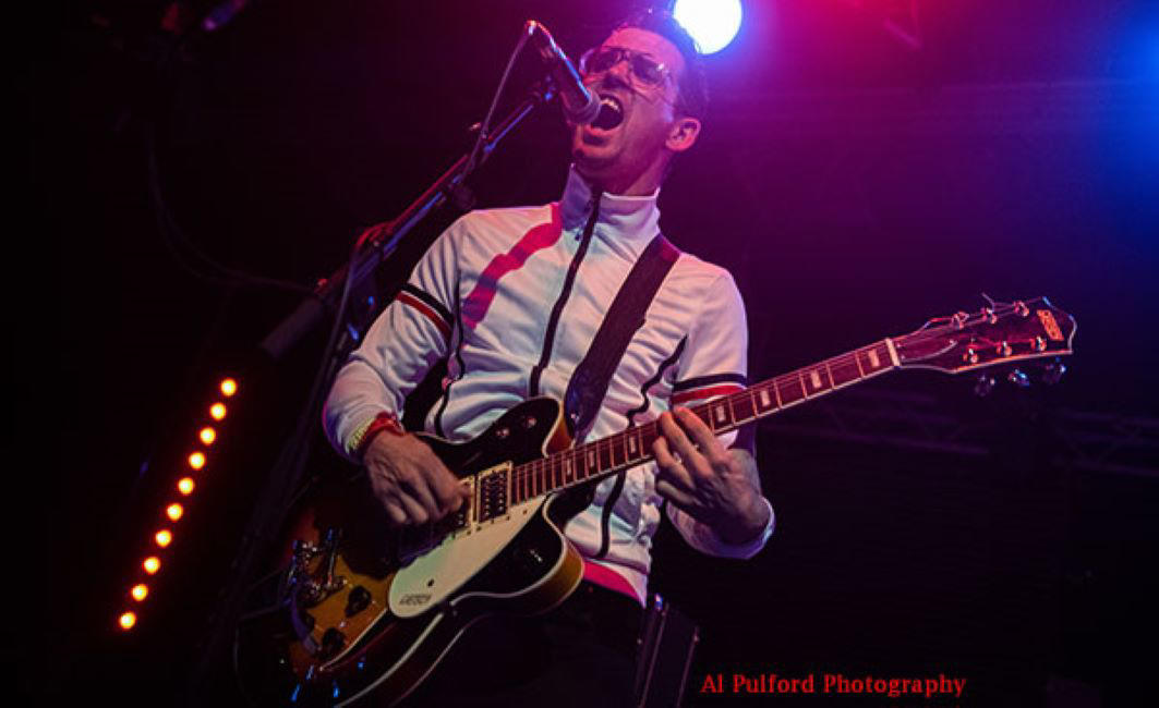 a man playing a guitar on a stage