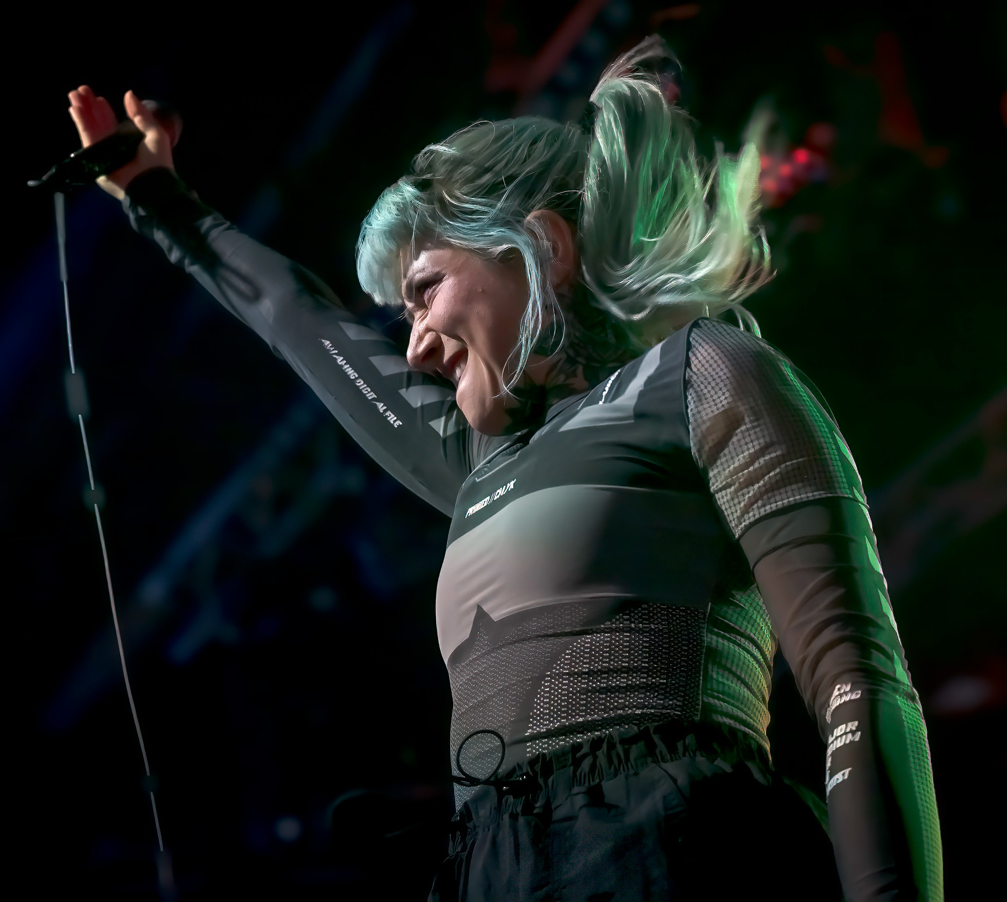 a person with green hair holding a microphone
