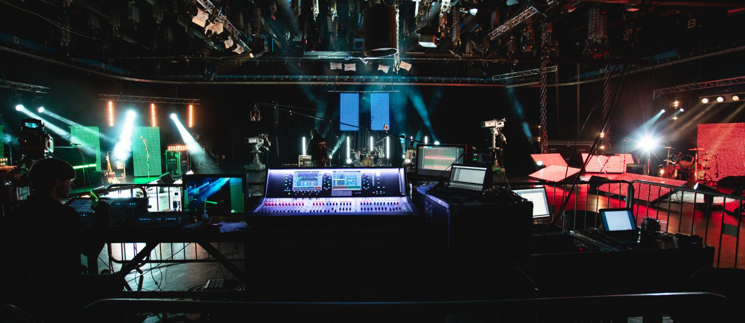 a large room with a stage and computers