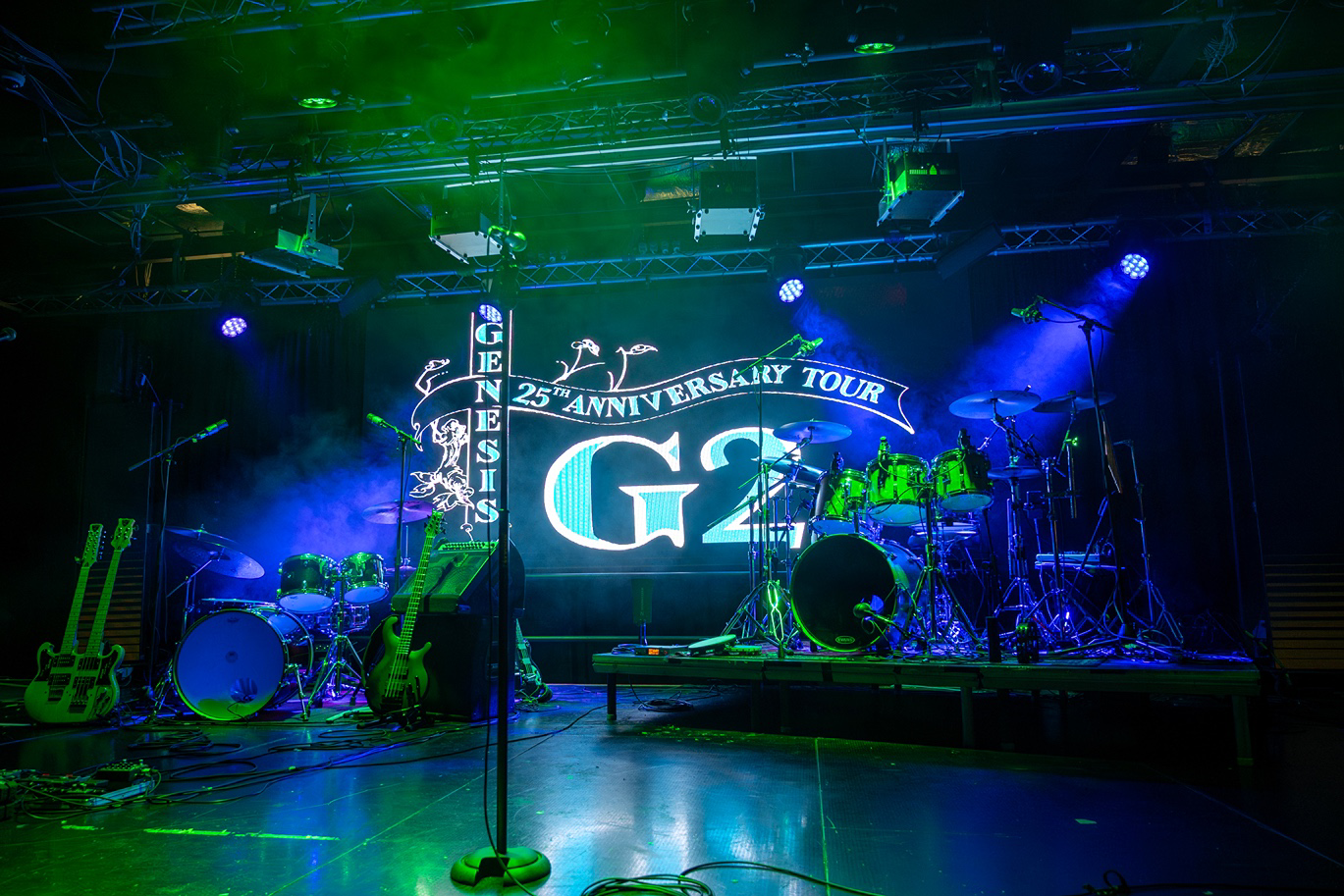 a stage with a drum set and a stage with a green light