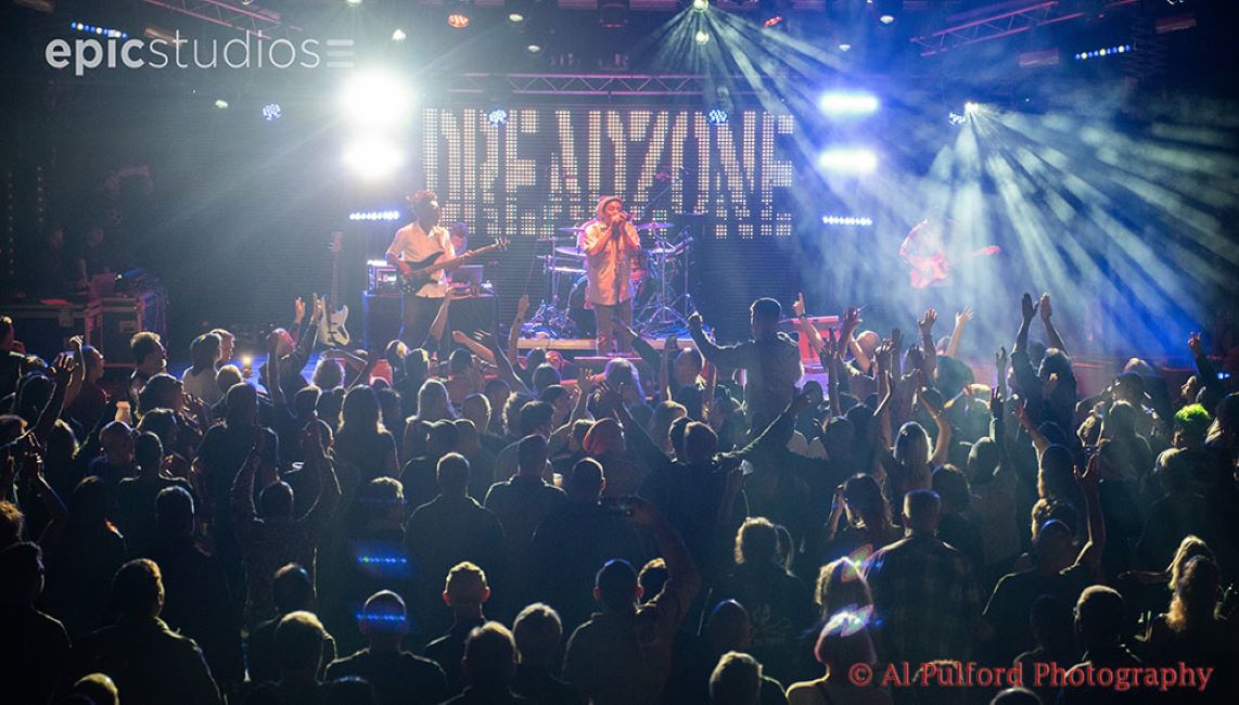 a group of people on a stage with a crowd watching