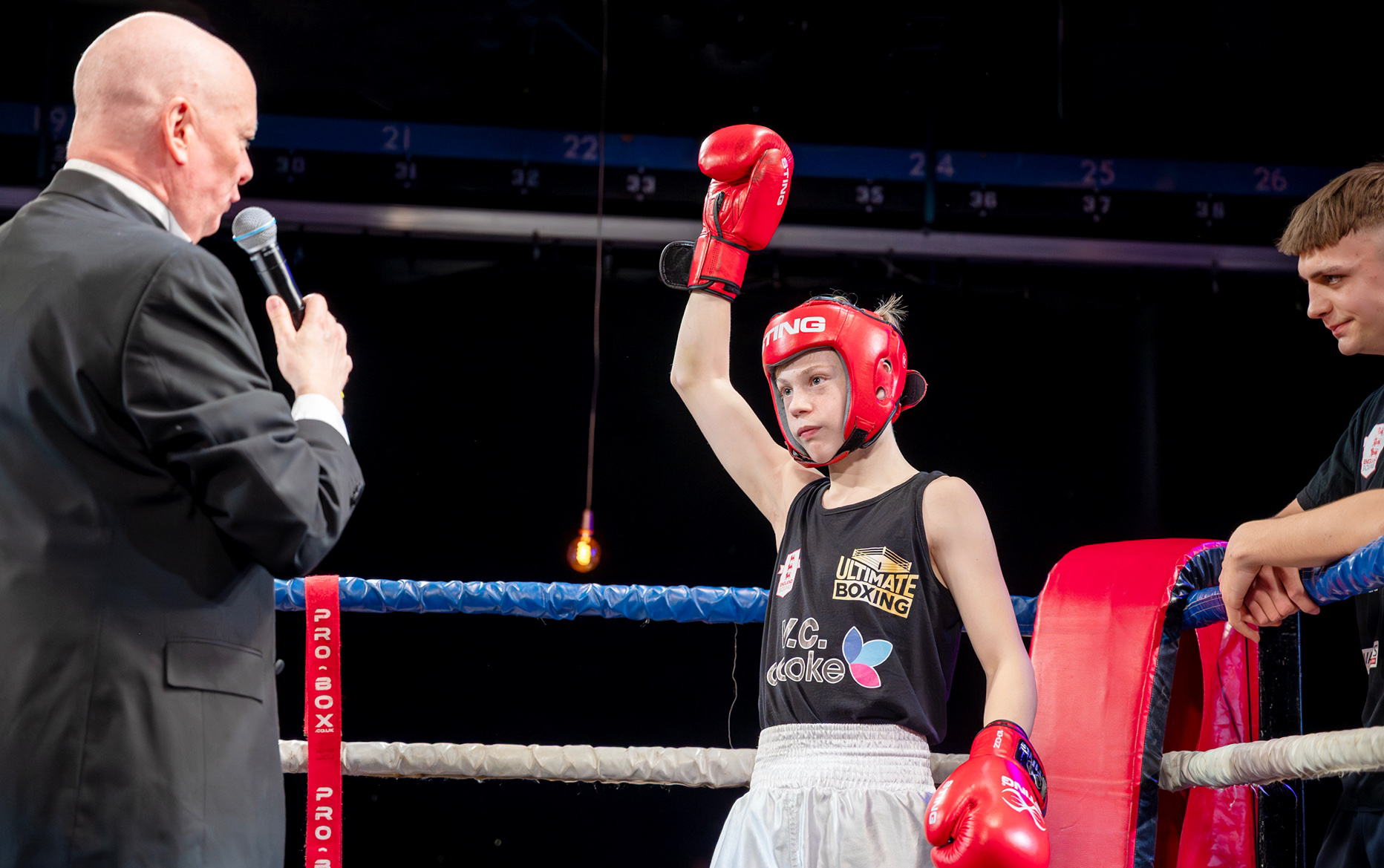 a person wearing a red helmet and boxing gloves holding a microphone
