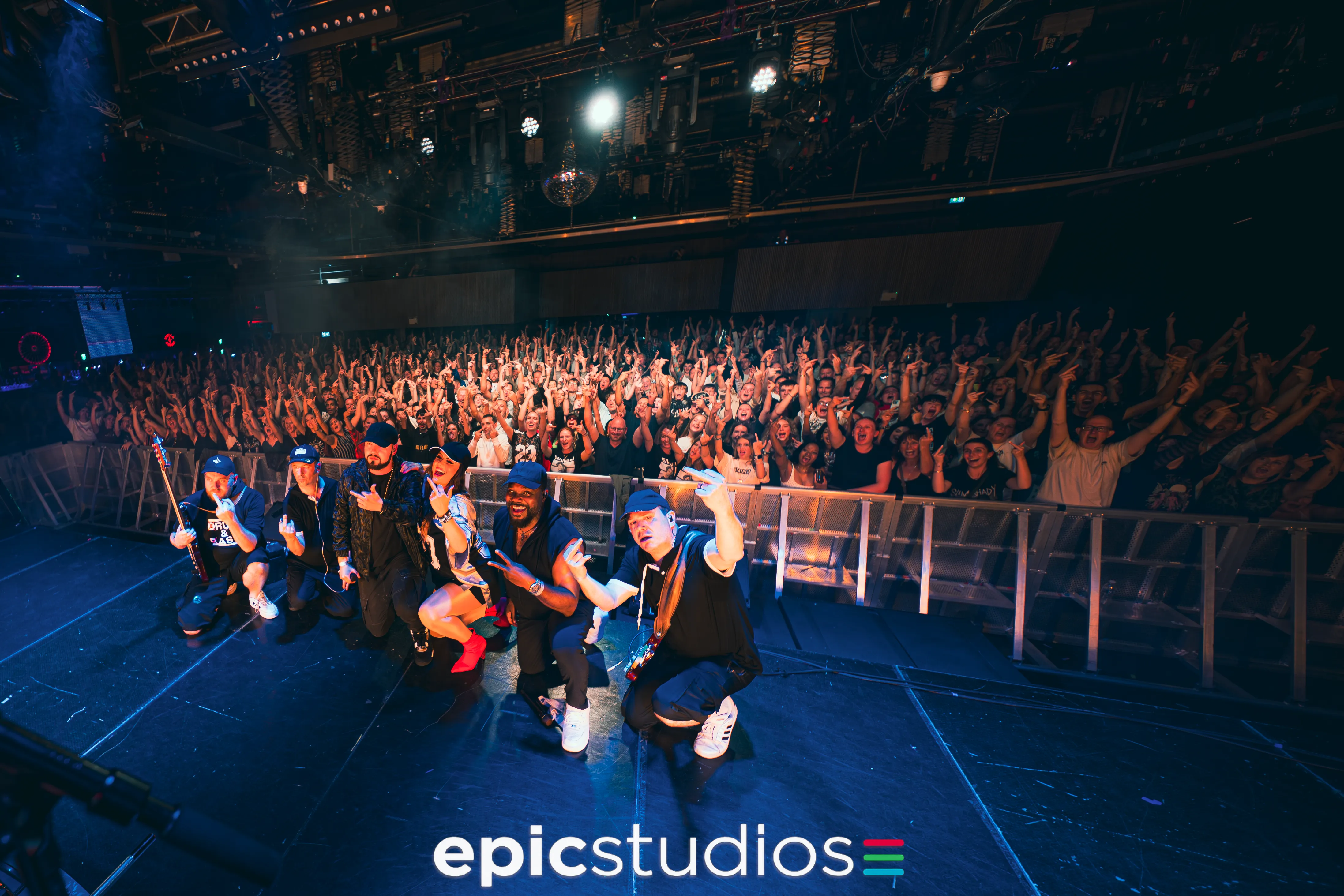 a group of people sitting on a stage with a crowd watching