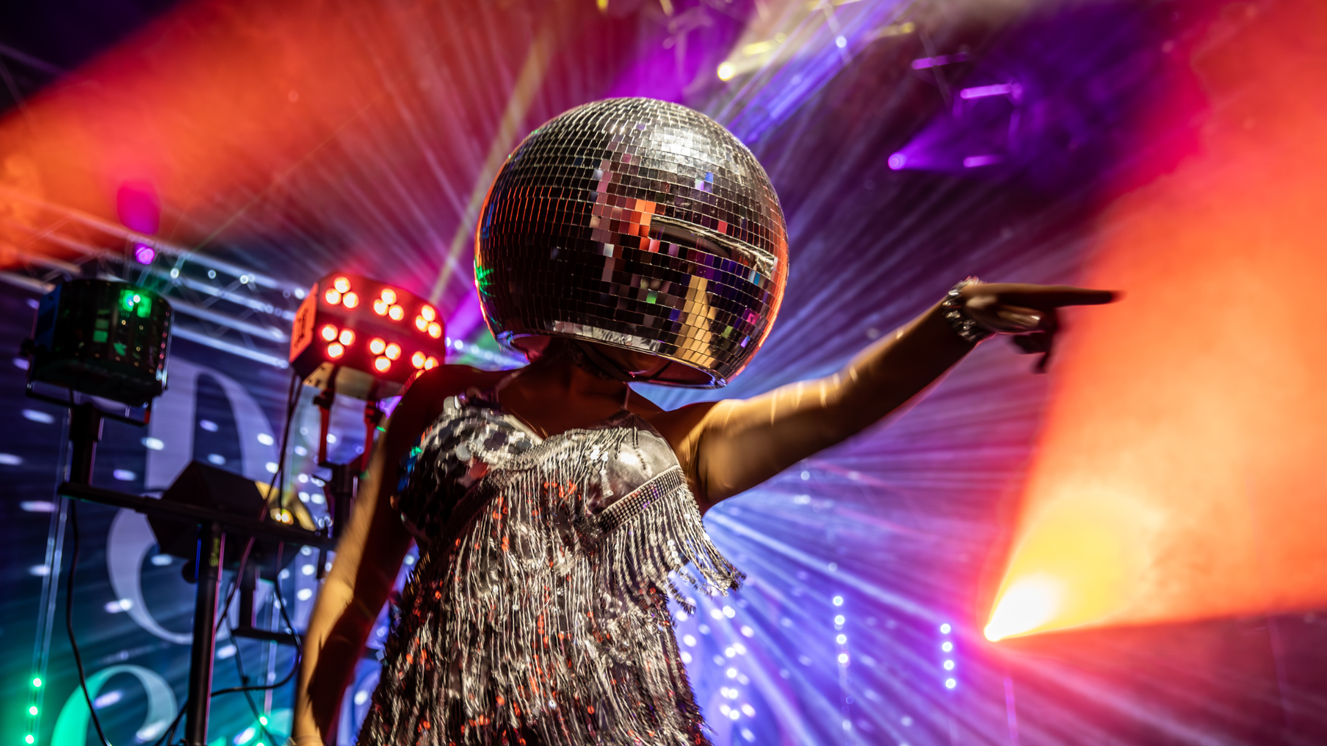 a person with a hat and a microphone on a stage