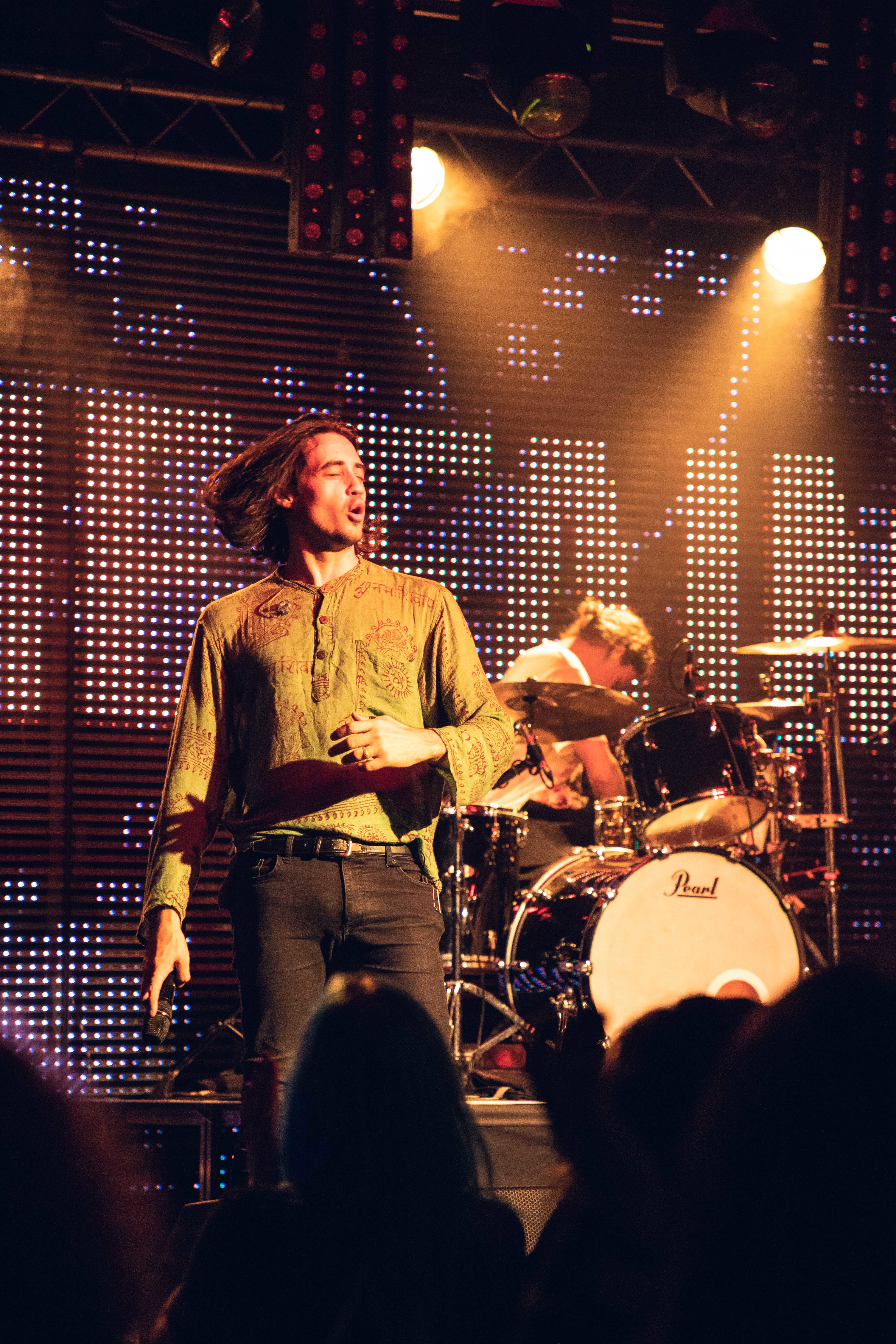 a man on a stage with a microphone and a crowd watching