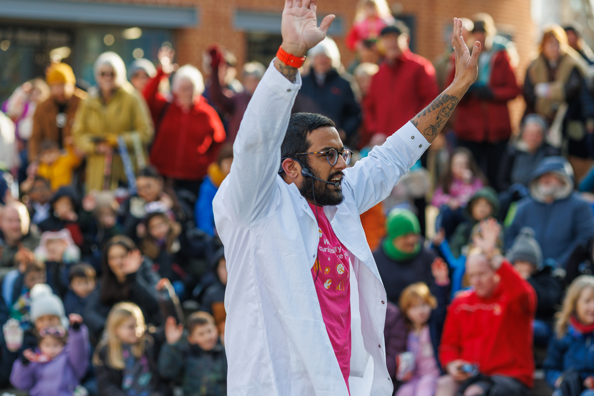 a man in a white robe with his arms raised in front of a crowd